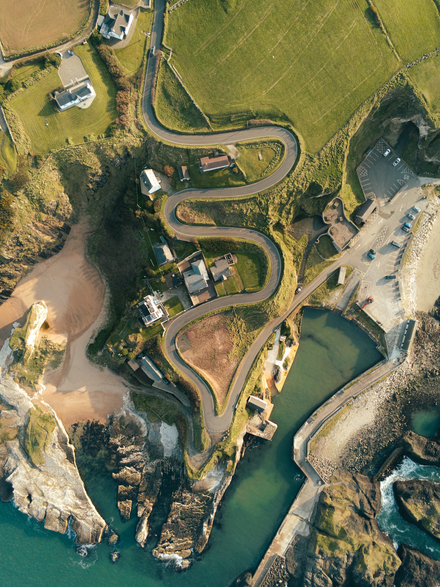 Aerial view of the winding road and coastline at Ballintoy Harbour
