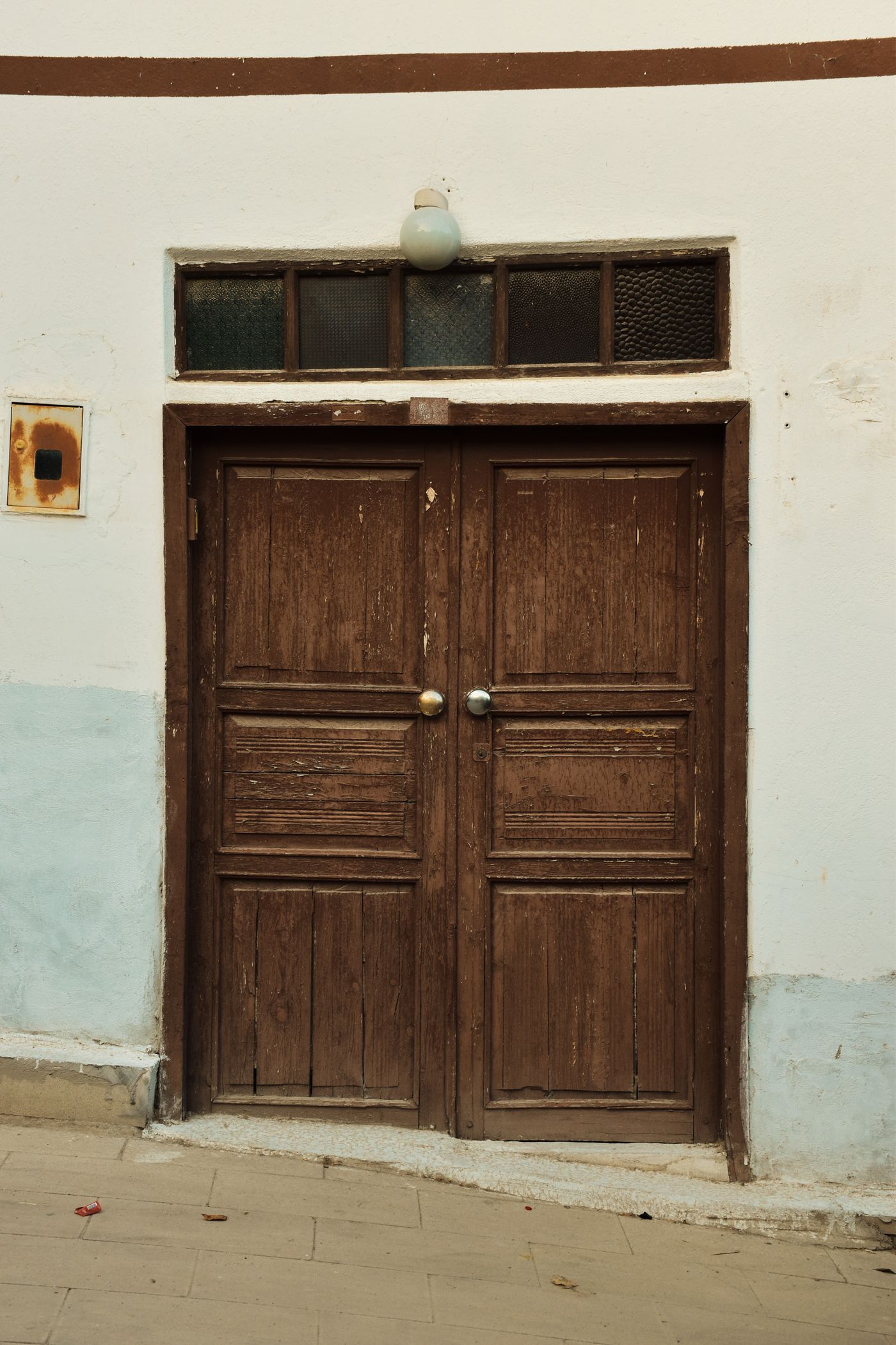 A closed weathered wooden double door, illustrating Tyrion’s unresolved search.