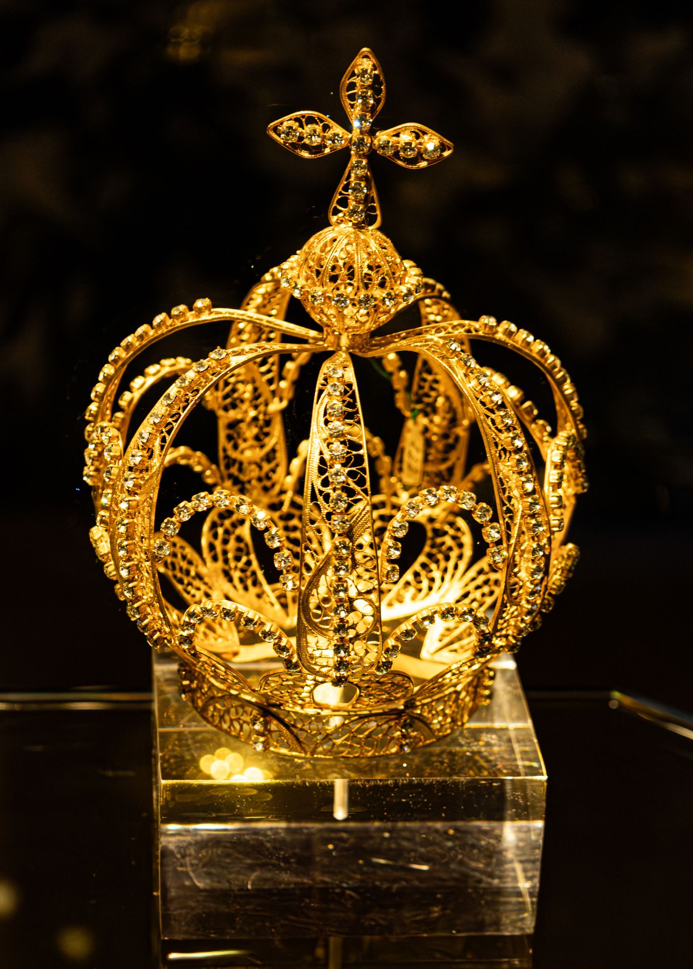 An ornate gold crown with jewel details, illustrating the symbolism of monarchy.