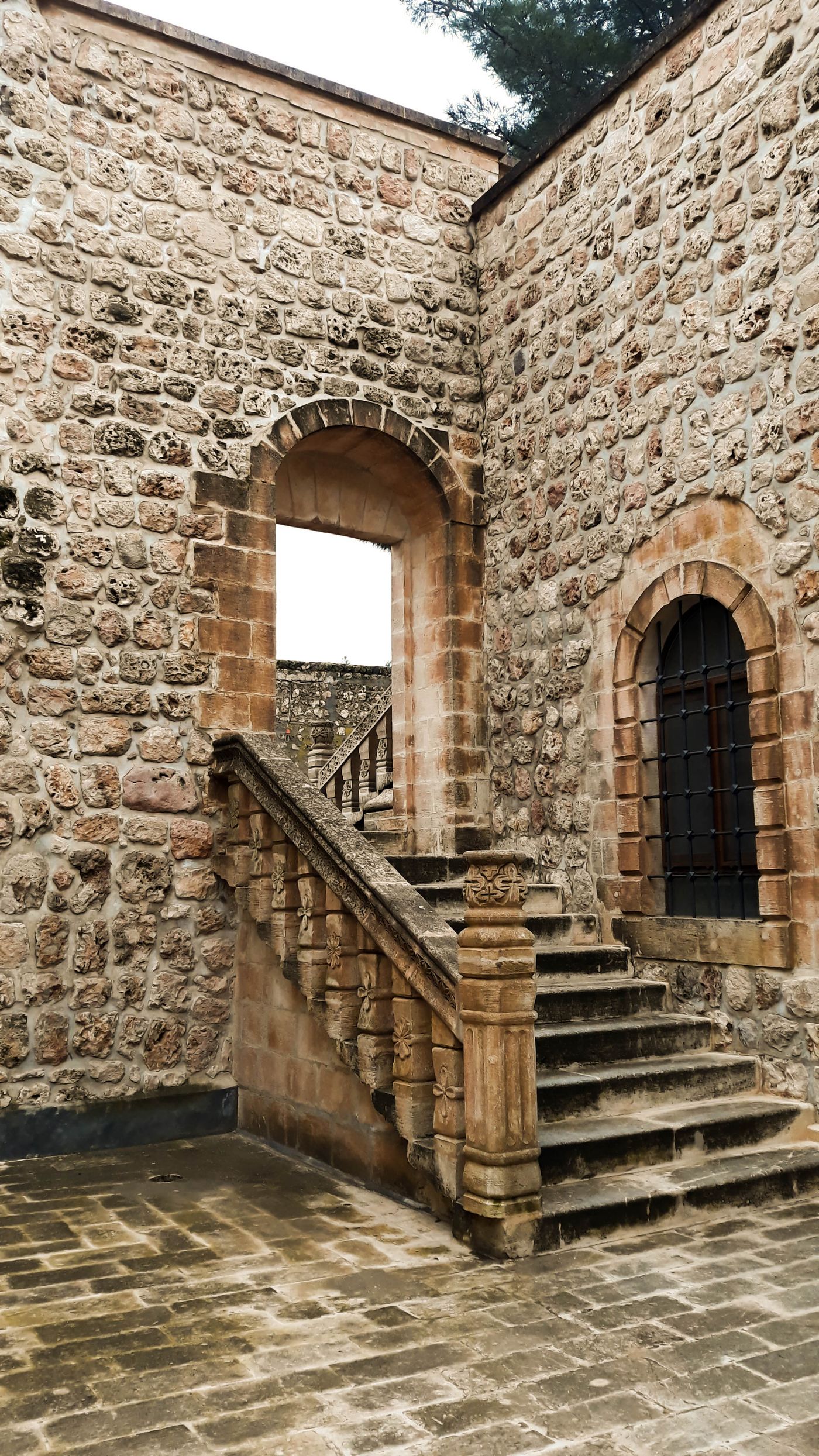 A narrow stone staircase climbing through castle walls, illustrating social ascent.